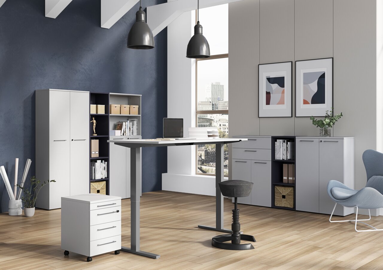 XORA Archiefrek LEGEND II Moderne kantooromgeving met een in hoogte verstelbaar bureau, een rolcontainer en archiefkasten in een lichte ruimte met grote ramen, zijaanzicht.