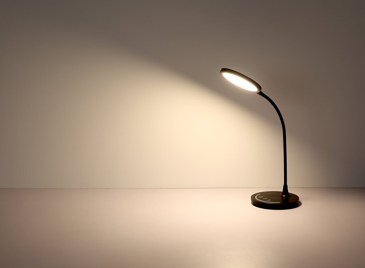 Moderne Tischleuchte mit flexiblem Hals und rundem Leuchtkopf, seitliche Perspektive