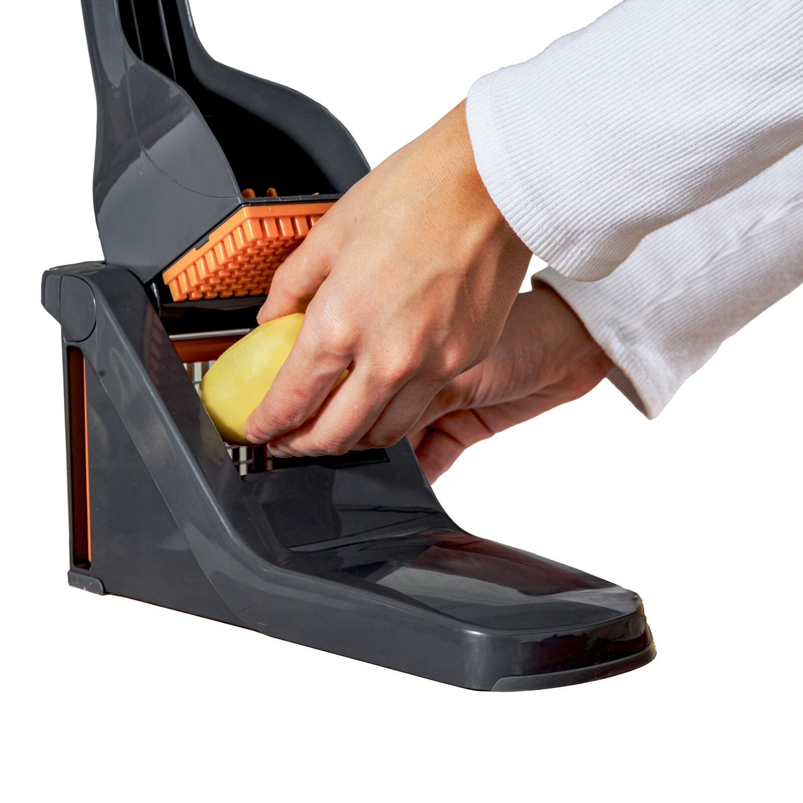 Close-up zijaanzicht van een hand die een geschilde aardappel door een grijs-oranje keukenmandoline met rooster snijdt op een witte achtergrond