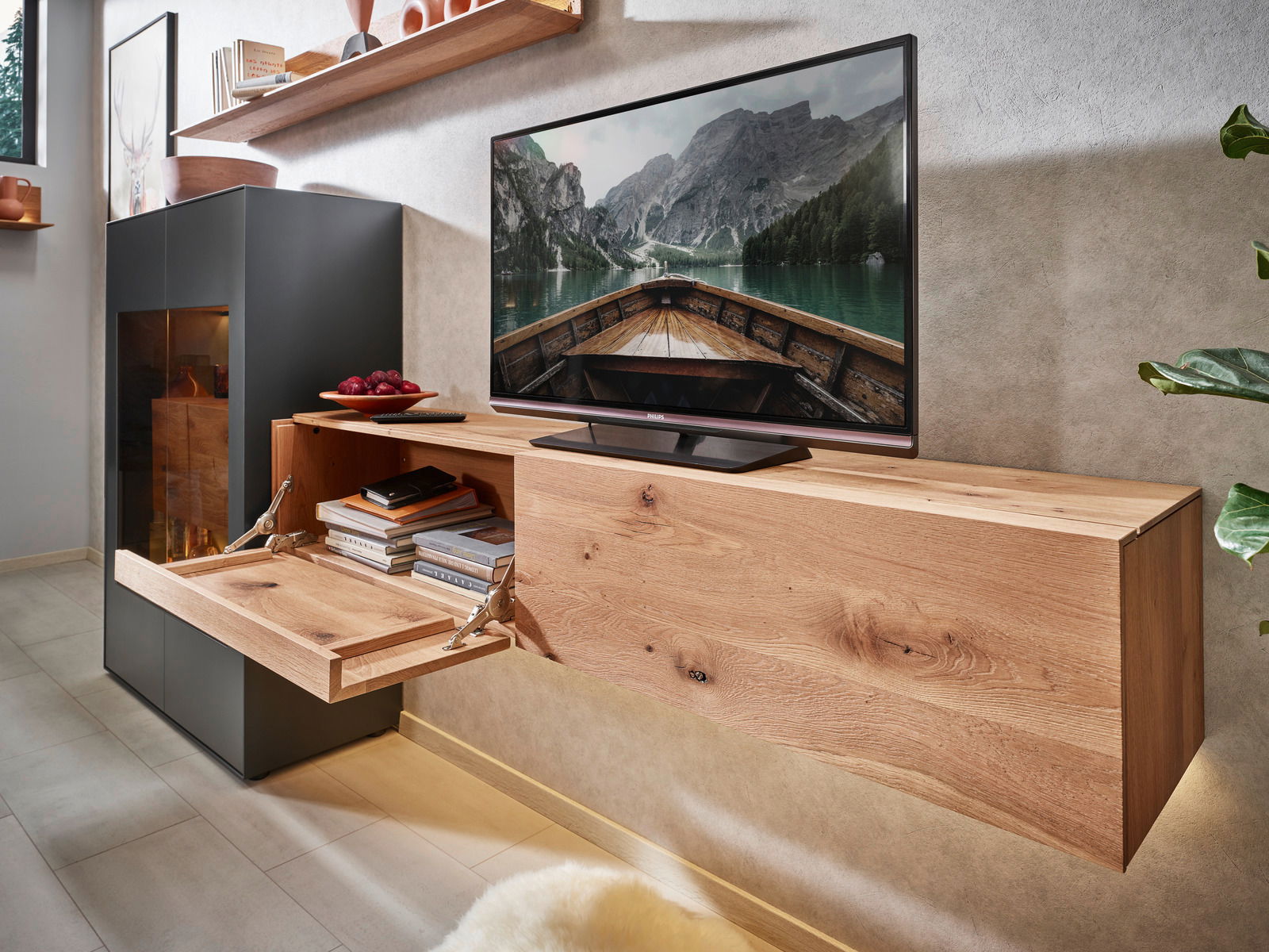 Moderne Wandkombination aus Holz mit integriertem Stauraum, TV und Dekorationen, seitliche Perspektive.