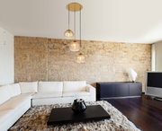 Moderne Hängeleuchte mit drei Glaskugeln in einem stilvollen Wohnzimmer, seitliche Perspektive