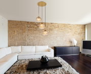 Moderne Hängeleuchte mit drei Glaskugeln in einem stilvollen Wohnzimmer, seitliche Perspektive