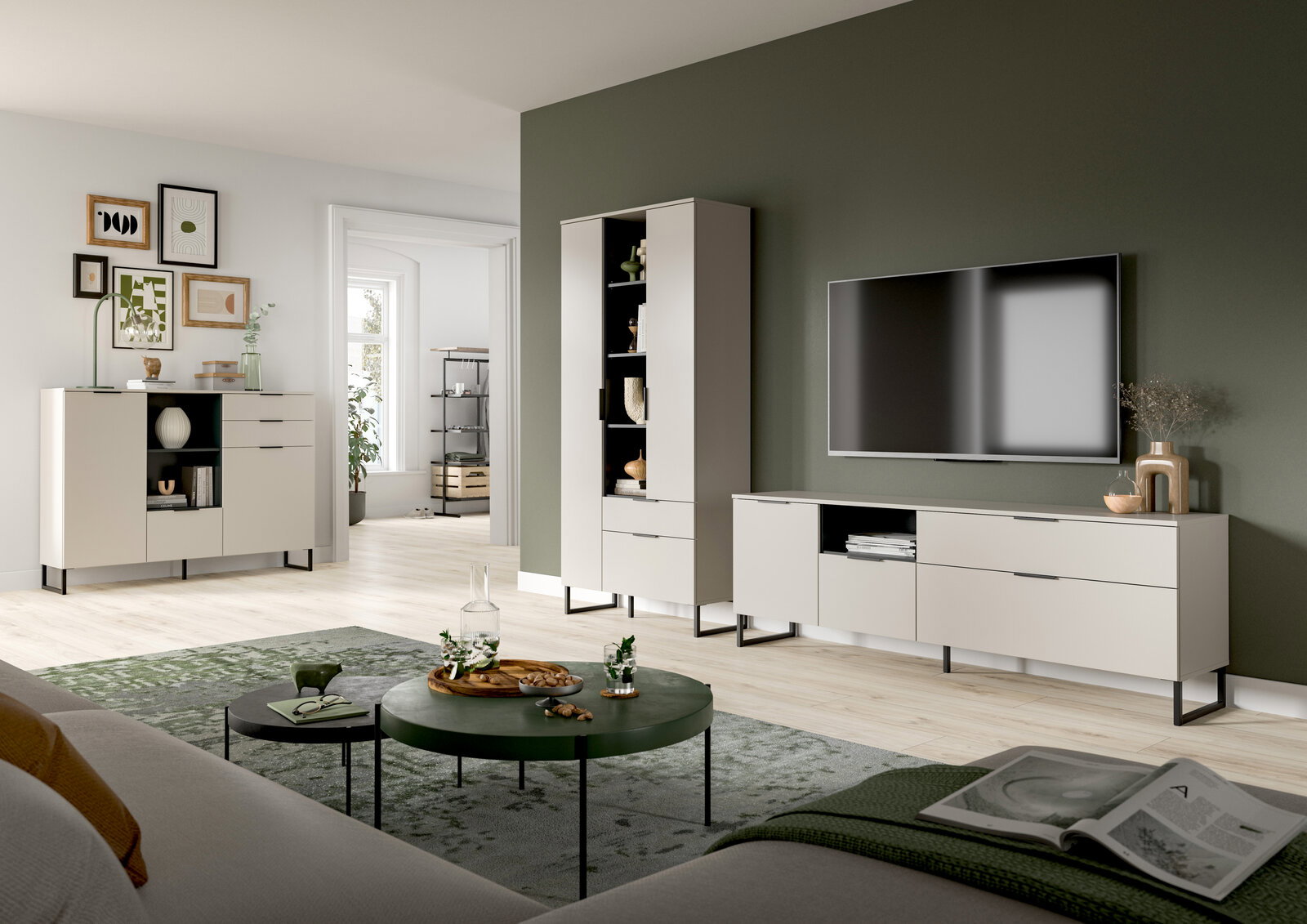 Modernes Wohnzimmer-Set mit weißem TV-Lowboard, hoher Vitrine und Sideboard auf schwarzen Metallfüßen vor olivgrüner Wand, TV an der Wand montiert; Perspektive: frontale Weitwinkelansicht aus leicht niedriger Sitzhöhe.