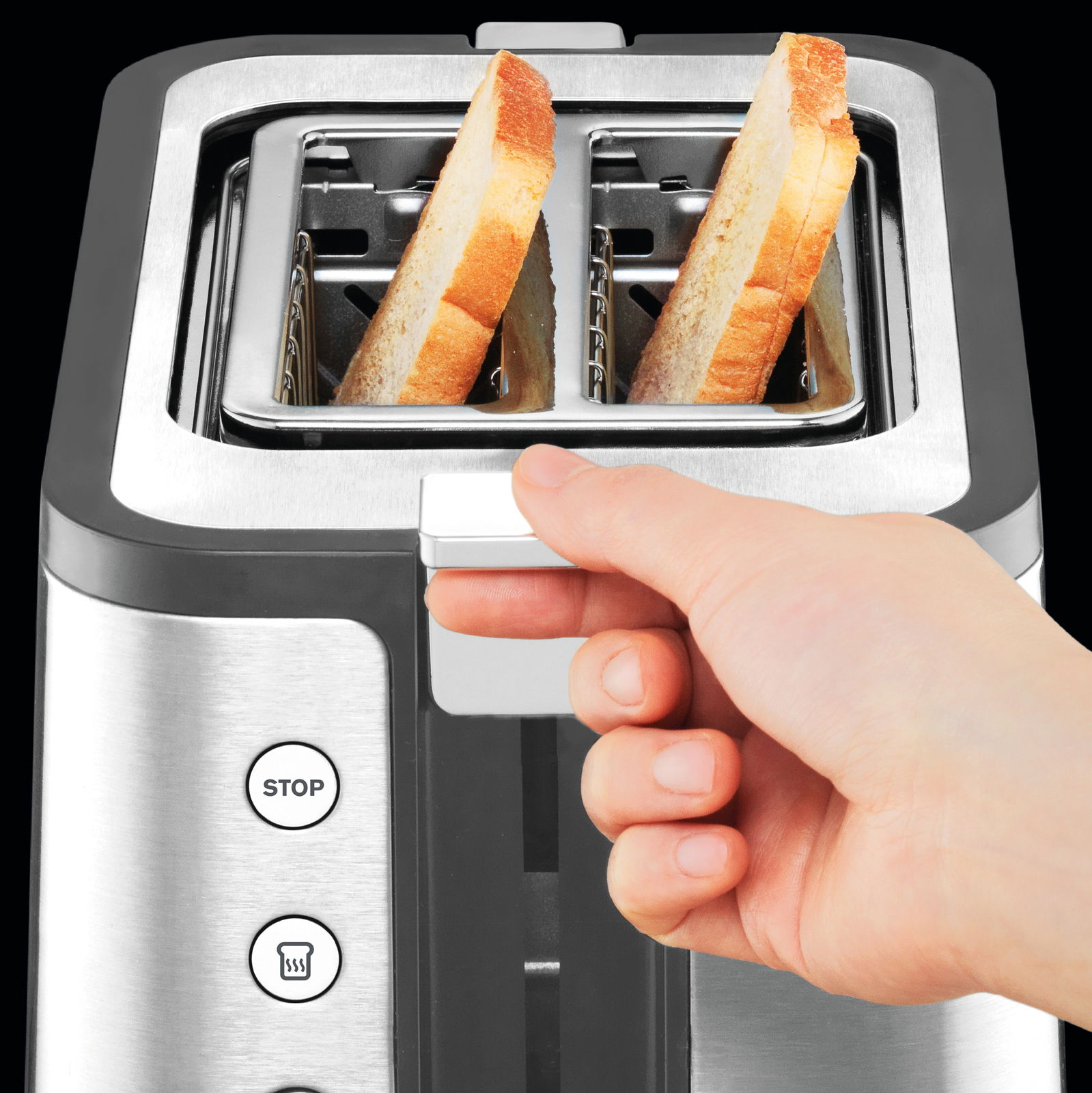Nahaufnahme eines Toasters mit zwei Toastscheiben, eine Hand betätigt den Hebel. Ansicht von oben.