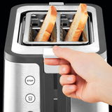 Nahaufnahme eines Toasters mit zwei Toastscheiben, eine Hand betätigt den Hebel. Ansicht von oben.