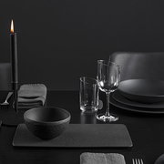 Elegante schwarze Dipschale aus der Manufacture-Serie, 60ml, auf einem stilvoll gedeckten Tisch mit Kerzenlicht, seitliche Perspektive.