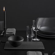 Elegante schwarze Dipschale aus der Manufacture-Serie, 60ml, auf einem stilvoll gedeckten Tisch mit Kerzenlicht, seitliche Perspektive.