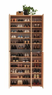 Vorderansicht eines XXL-Schuhschranks mit offenen Türen, gefüllt mit verschiedenen Schuhen und dekoriert mit einem Pflanzenarrangement oben.