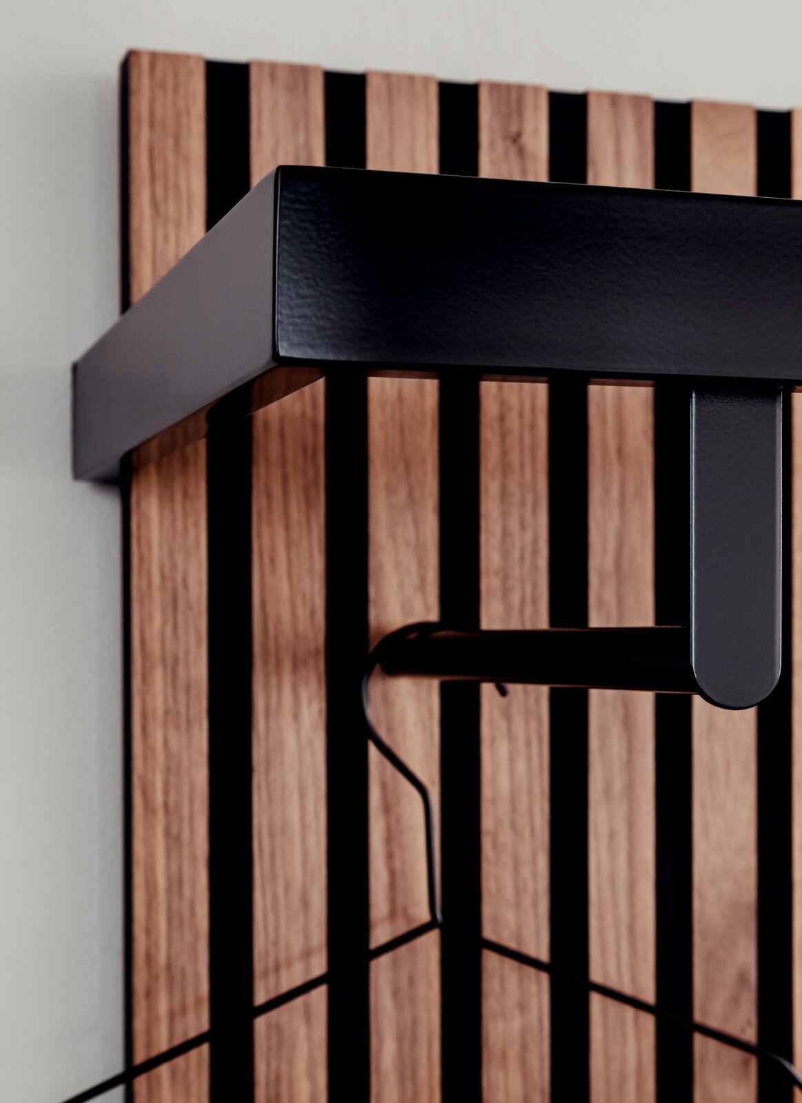 Nahaufnahme eines modernen Garderobenpaneels mit Holz- und Metallelementen, seitliche Perspektive.