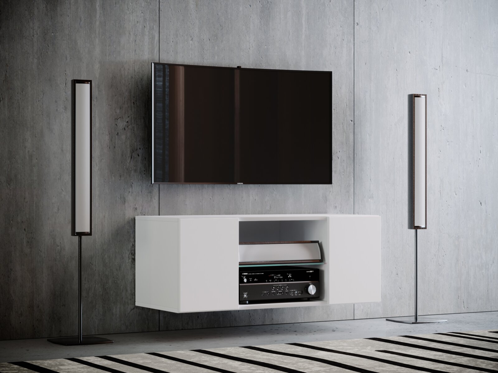 VCM TV-Lowboard JUSA Frontansicht eines modernen Wohnzimmer-Setups: wandmontierter Flachbildfernseher über einem weißen, schwebenden TV-Lowboard mit offenem Fach und AV-Receiver, flankiert von zwei schlanken Standlautsprechern vor grauer Betonwand.