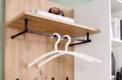 Kompaktgarderobe mit Holzregal und schwarzen Metallhaken, seitliche Perspektive