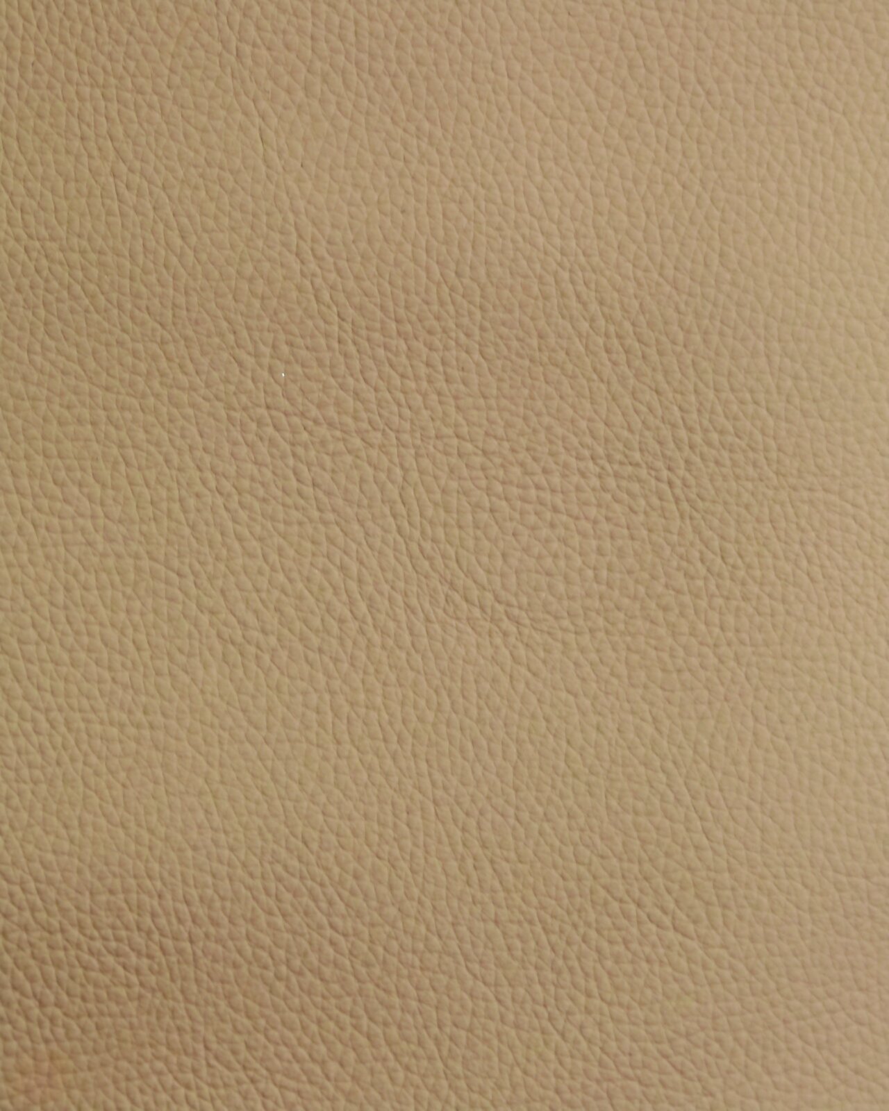 Nahaufnahme einer beige strukturierten Lederoberfläche, verwendet für einen Stuhl.