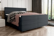Boxspringbett in modernem Design, seitliche Perspektive, mit dunklem Stoffbezug und gemütlicher Bettwäsche in einem stilvollen Schlafzimmer.