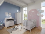 Kinderzimmer mit einem weißen Unterstell-Wandregal, Wickelkommode und Gitterbett, aus der Perspektive von der Zimmerecke aus gesehen.
