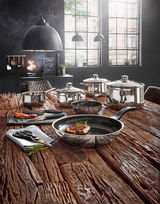 Kochtopf-Starter-Set 10-tlg. auf rustikalem Holztisch in moderner Küche, Perspektive von vorne.