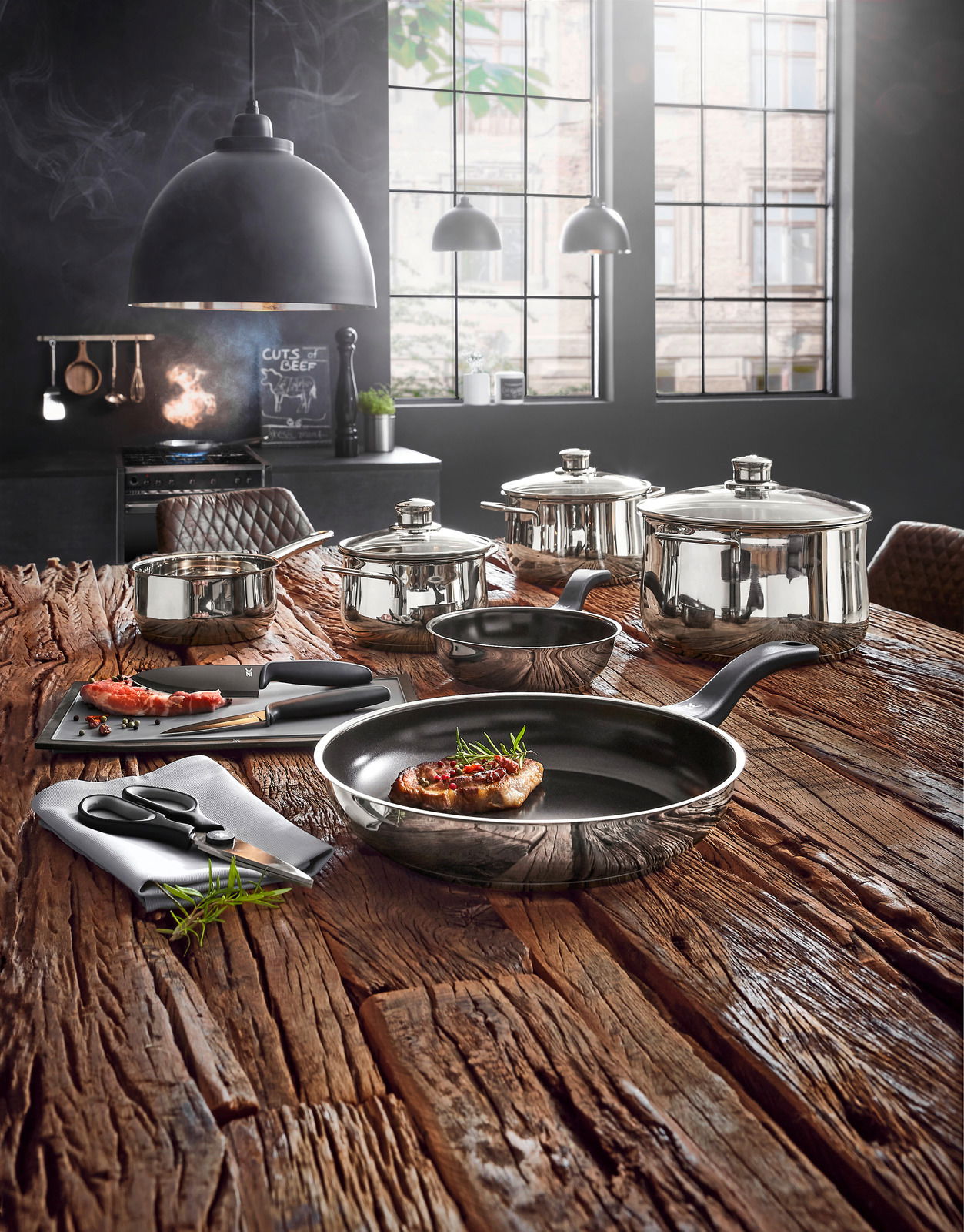 Kochtopf-Starter-Set 10-tlg. auf rustikalem Holztisch in moderner Küche, Perspektive von vorne.