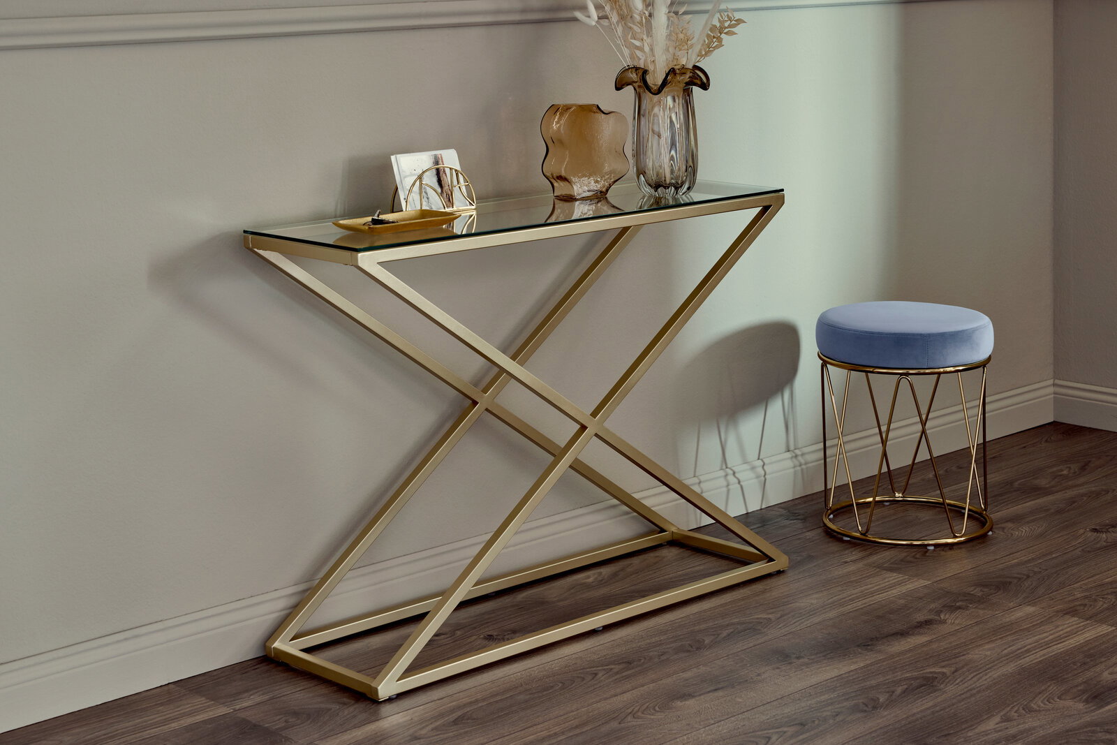 Moderne Konsole mit goldfarbenem Metallgestell und Glasplatte, seitliche Perspektive