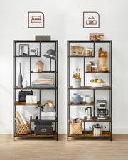 Zwei hohe Regalständer im Industrial-Design mit schwarzem Metallrahmen und braunen Holzablagen, frontale Ansicht, dekorativ mit Wohn- und Küchenaccessoires bestückt vor weißer Wand.
