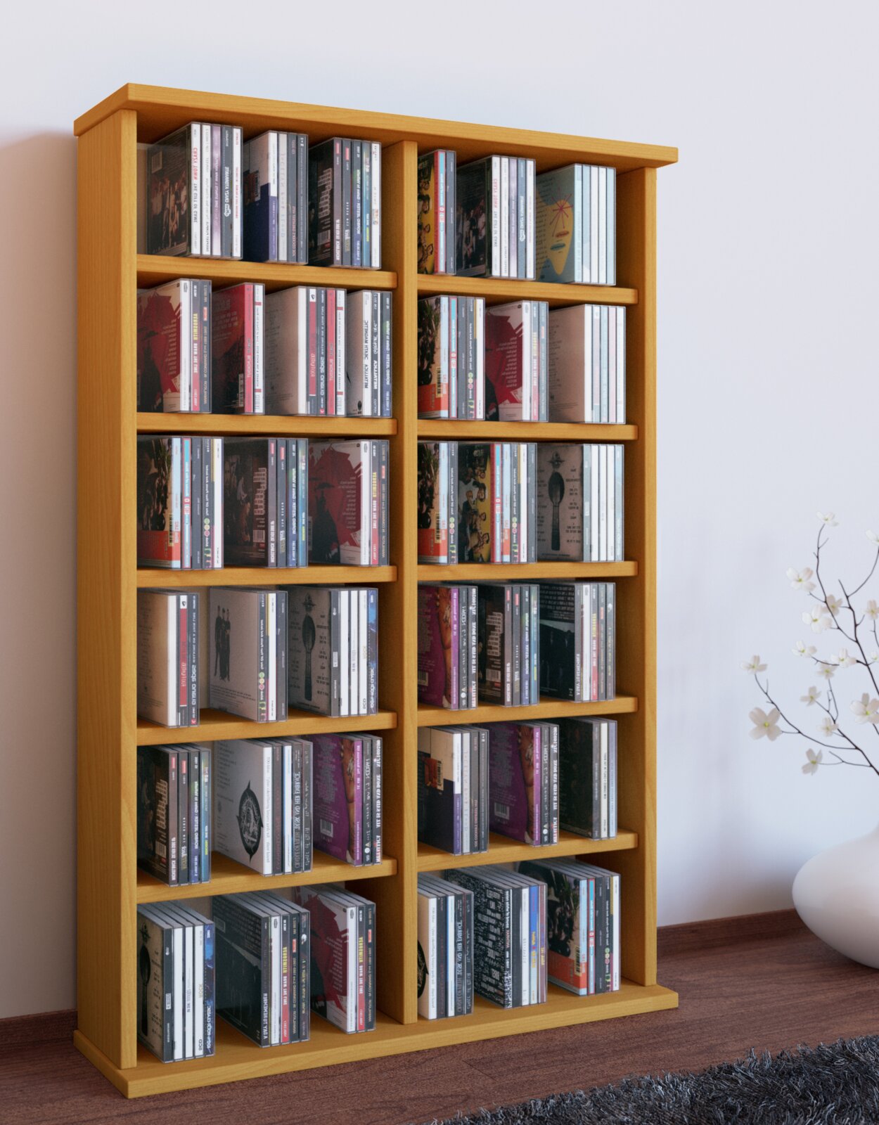 Hohes, helles Holz-CD-Regal mit mehreren Fächern, gefüllt mit CDs, freistehend an der Wand im Wohnraum; Perspektive: leicht von links vorn aufgenommen.
