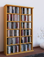 Hohes, helles Holz-CD-Regal mit mehreren Fächern, gefüllt mit CDs, freistehend an der Wand im Wohnraum; Perspektive: leicht von links vorn aufgenommen.