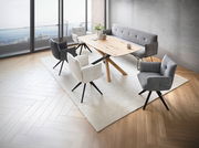 Moderne Esszimmermöbel in einem stilvollen Raum mit Panoramablick, bestehend aus einem Holztisch, umgeben von verschiedenen gepolsterten Armlehnstühlen und einer grauen Bank. Perspektive von oben.