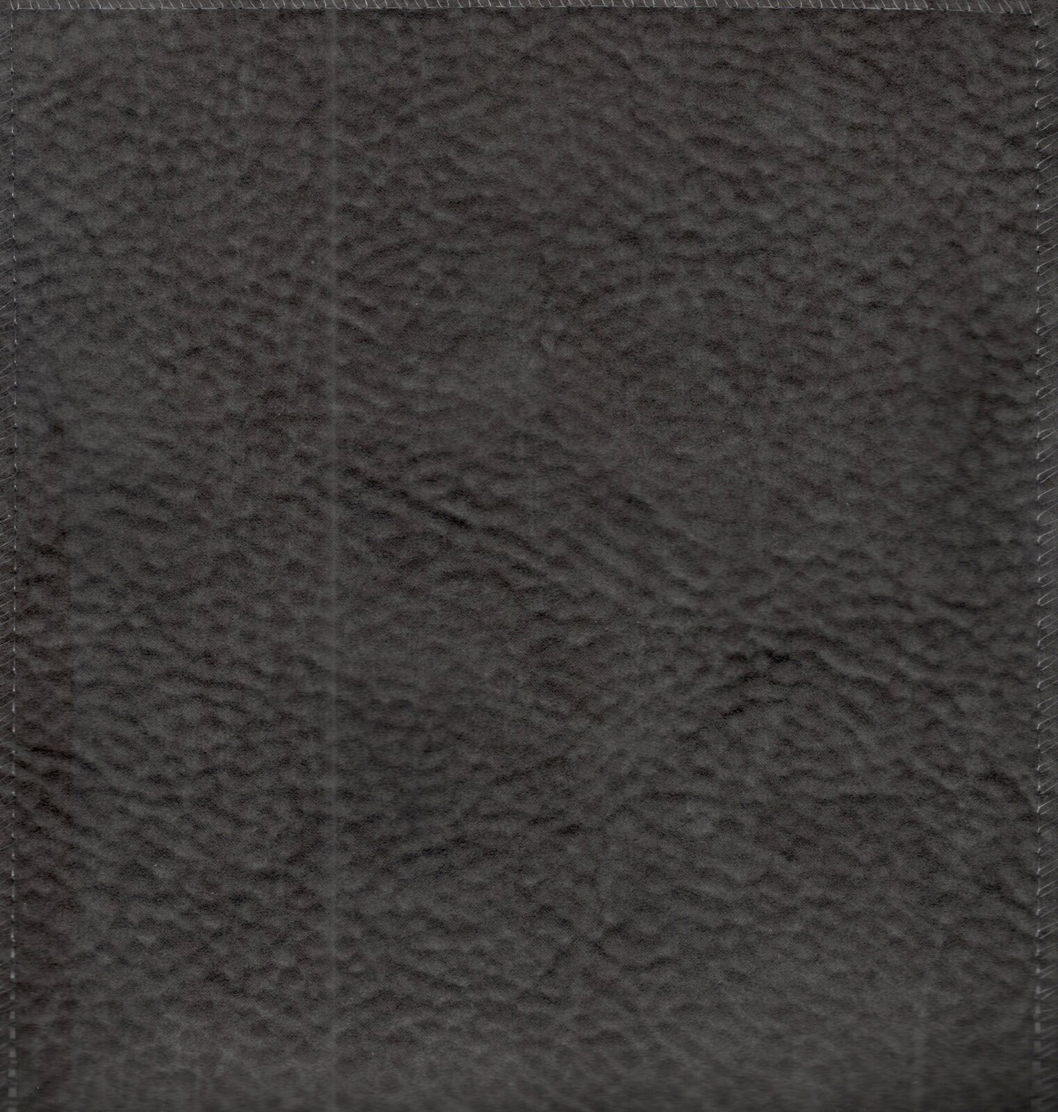 Nahaufnahme von dunkelgrauem, leicht strukturiertem Material (Texturdetail), aufgenommen in Frontalansicht von oben