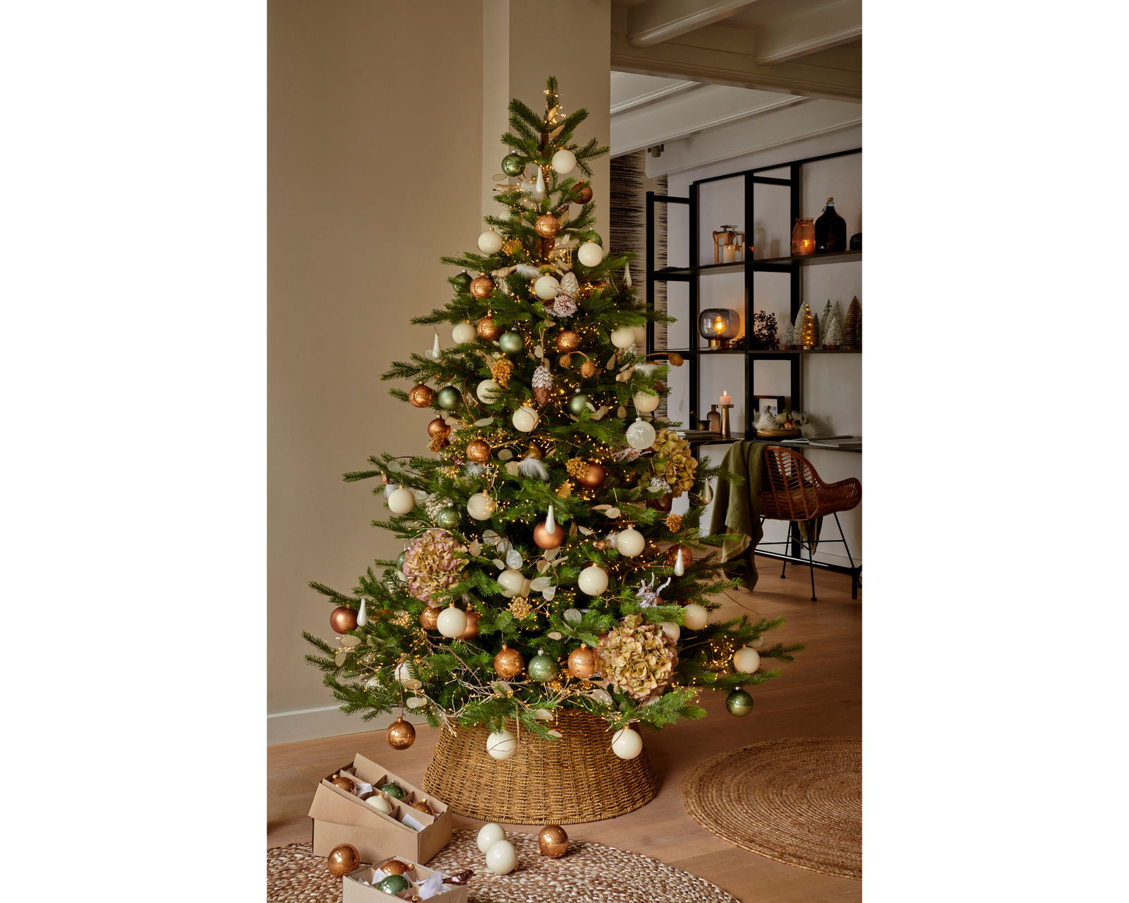 Weihnachtsbaum mit goldenen, grünen und weißen Kugeln, geschmückt in einem gemütlichen Wohnzimmer, seitliche Perspektive.