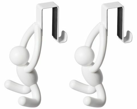 Zwei weiße Türhaken in Form von Figuren, die an einer Kante hängen. Perspektive: Frontalansicht.