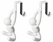 Zwei weiße Türhaken in Form von Figuren, die an einer Kante hängen. Perspektive: Frontalansicht.