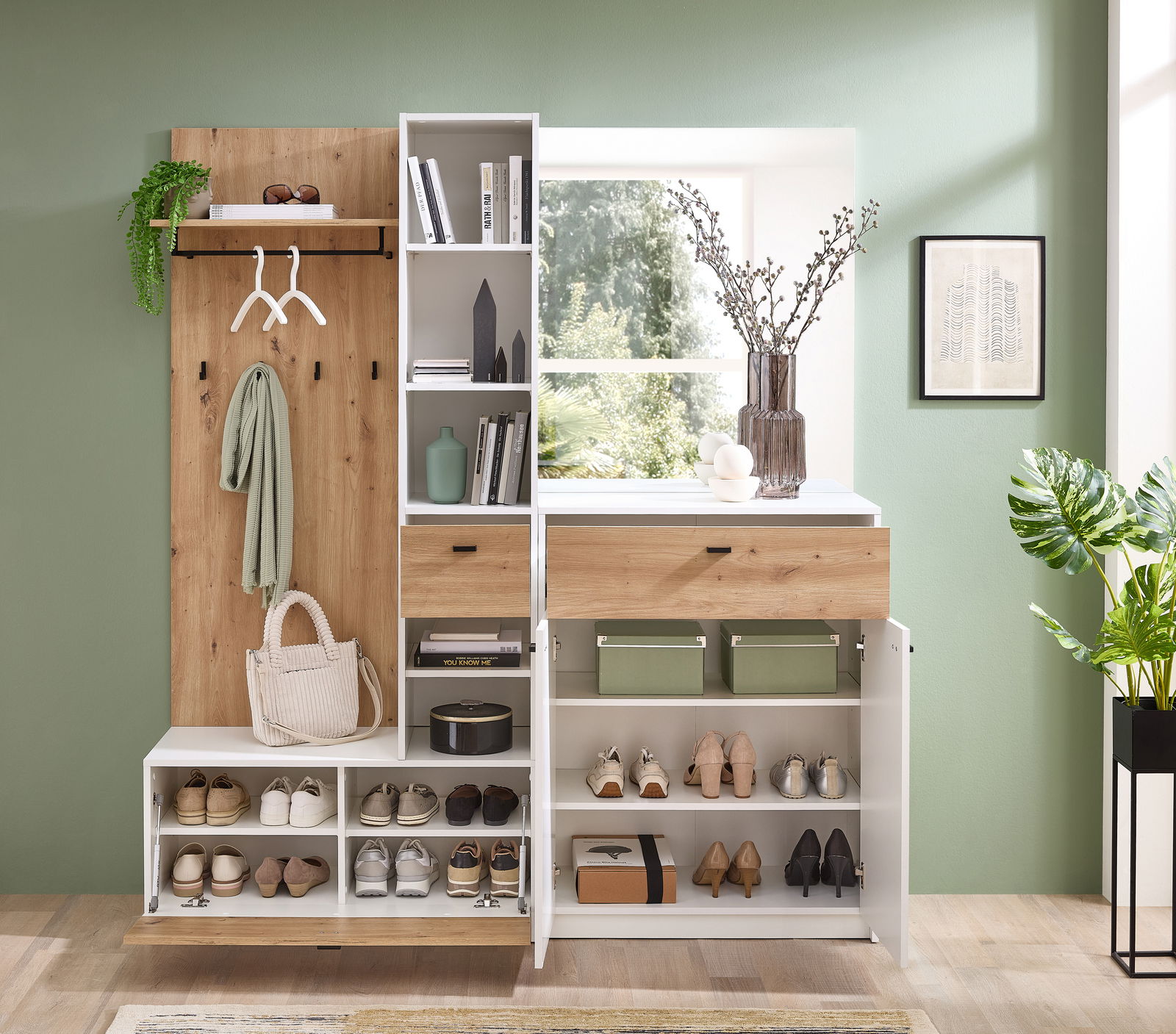 Kompaktgarderobe in moderner Einrichtung, frontal fotografiert, mit Stauraum für Schuhe, Haken für Kleidung und Regalen für Bücher und Dekoration.