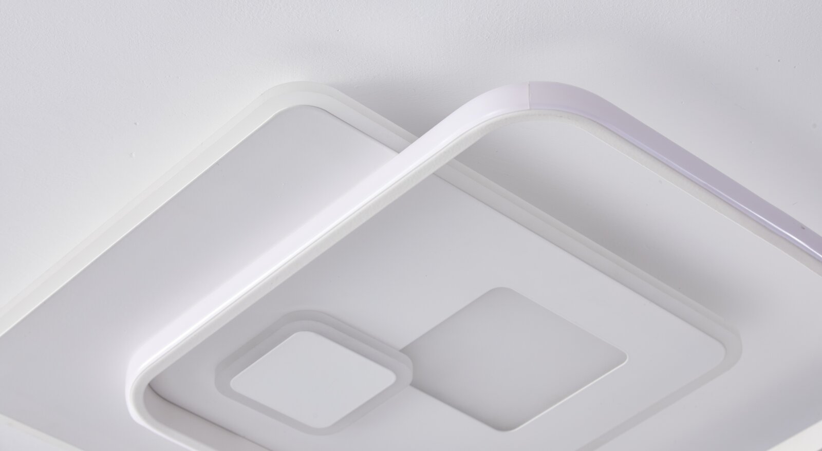 Moderne LED-Deckenleuchte in Nahaufnahme von unten, mit geometrischem Design und weißem Finish.