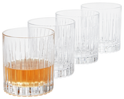 Vier Whiskygläser im Set, eines mit Whisky gefüllt, aus seitlicher Perspektive fotografiert.