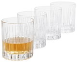 Vier Whiskygläser im Set, eines mit Whisky gefüllt, aus seitlicher Perspektive fotografiert.