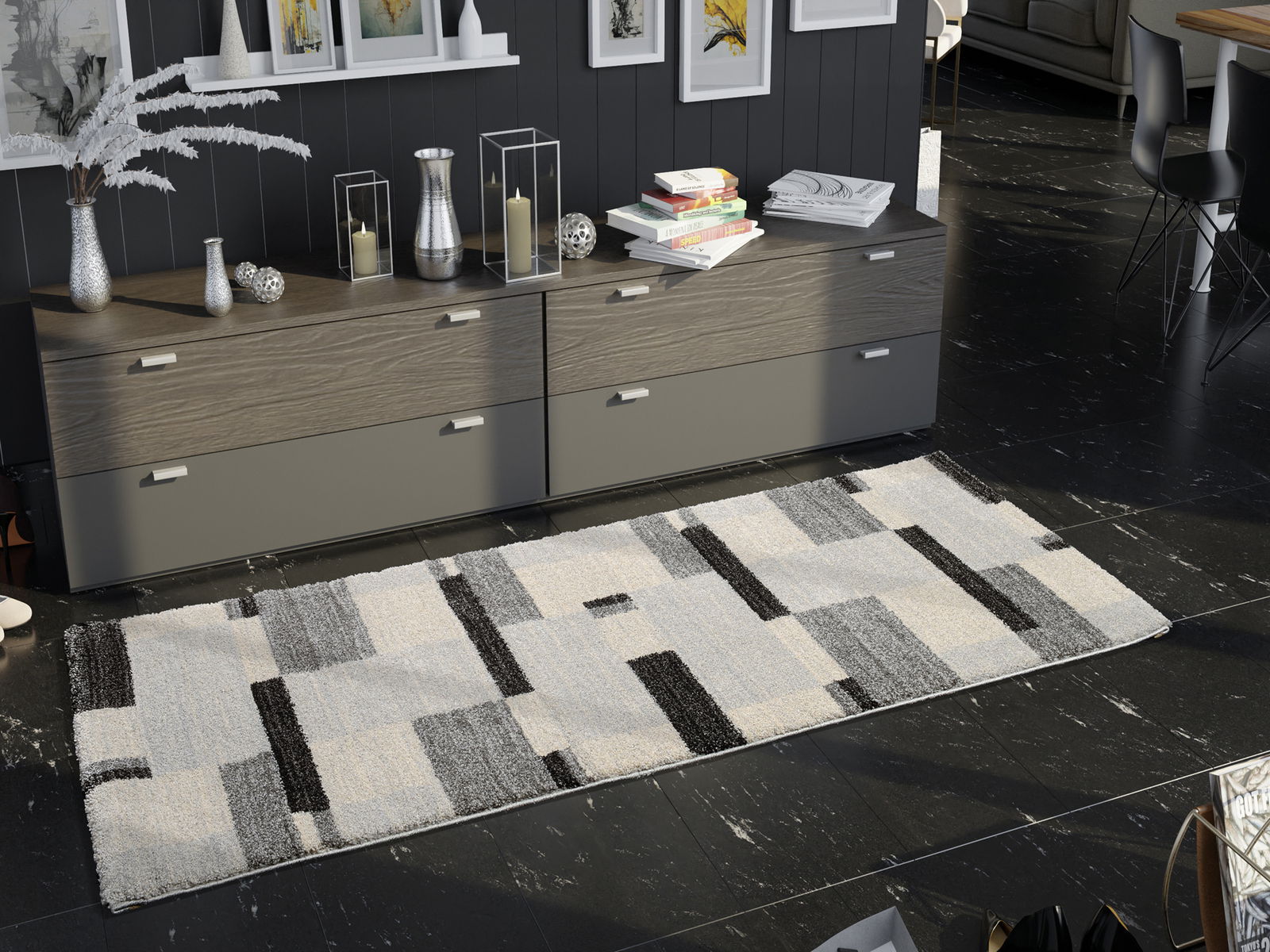 Moderner Teppich in Grau- und Schwarztönen mit geometrischem Muster, auf dunklem Boden vor einer Kommode liegend, aus der Vogelperspektive betrachtet.