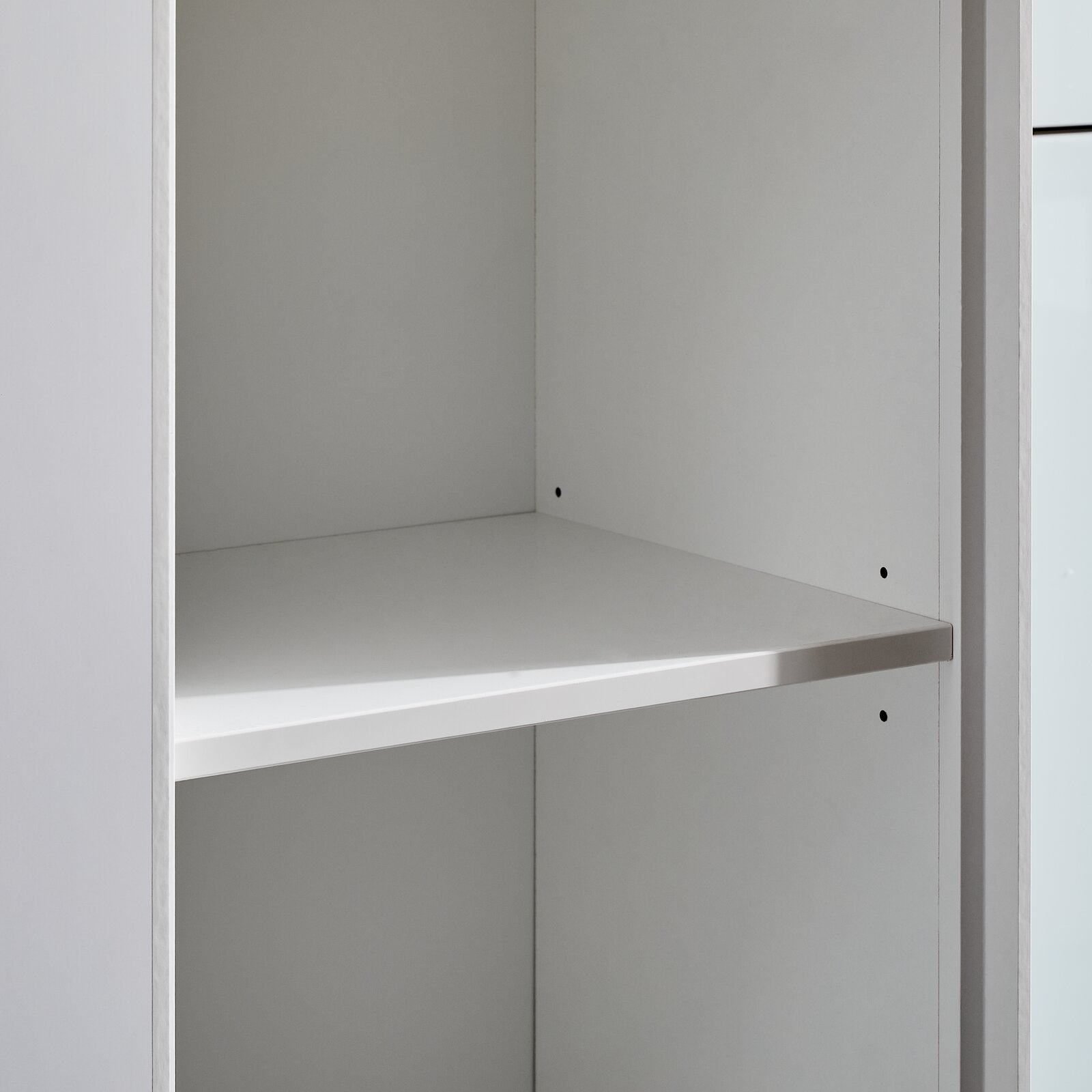 Nahaufnahme eines weißen, schmalen Aktenregals mit einem verstellbaren Einlegeboden, seitliche Perspektive.