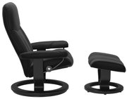 Zijaanzicht van een zwarte fauteuil met bijpassende voetenbank, modern ontwerp met ronde poten.