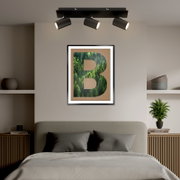 LED-Spot mit drei verstellbaren Strahlern, montiert an der Decke über einem Bett, aus der Perspektive des Bettes betrachtet.