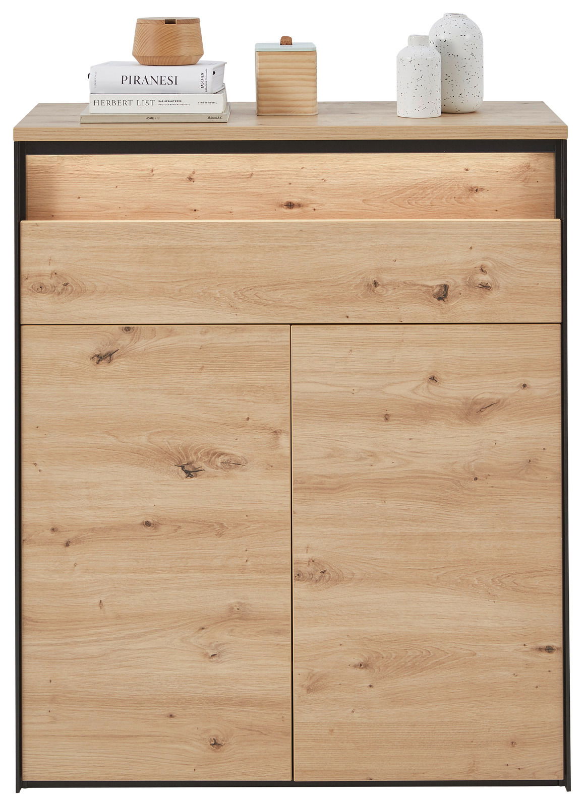 Schuhschrank aus hellem Holz mit zwei Türen und einer Schublade, frontal fotografiert. Dekoriert mit Büchern und Vasen auf der Oberseite.