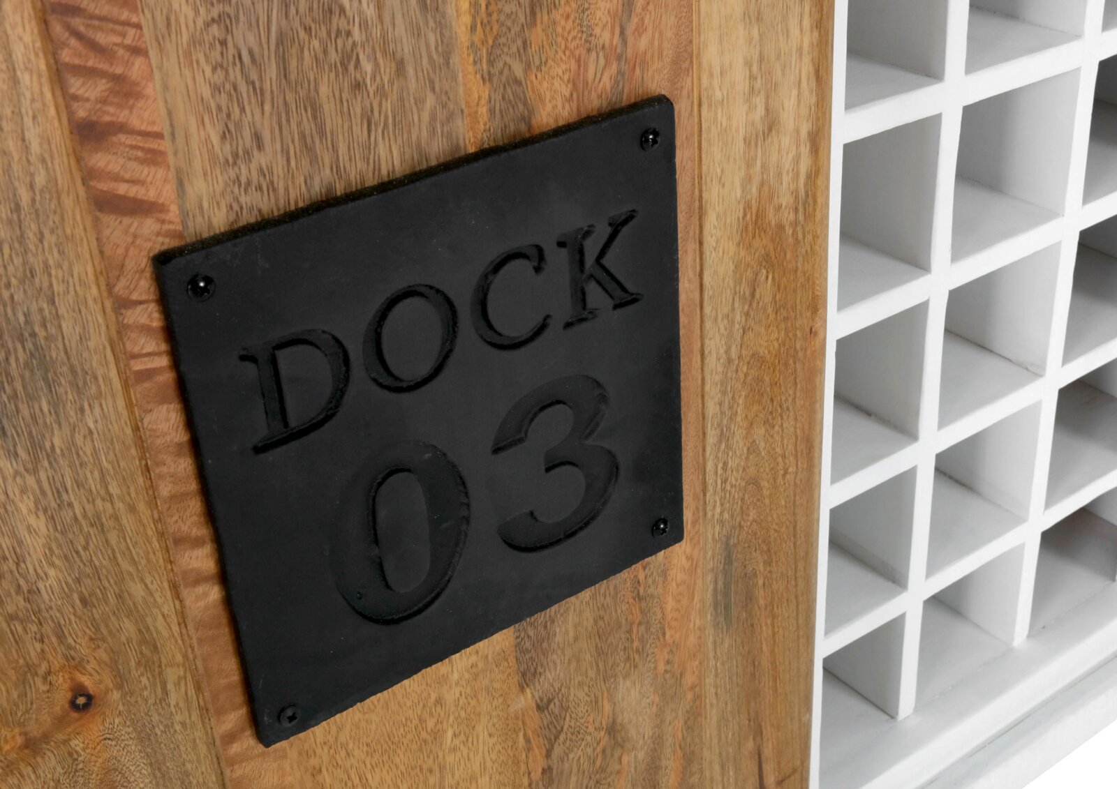 Nahaufnahme eines Weinregals mit Holzverkleidung und schwarzem Metallschild mit der Aufschrift 'DOCK 03', seitliche Perspektive