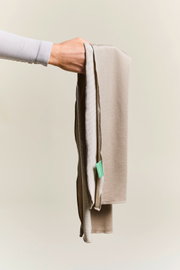 Beige Sporthandtuch, das von einer Hand gehalten wird, seitliche Perspektive