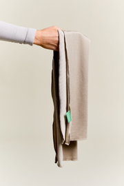 Beige sporthanddoek die door één hand wordt vastgehouden, zijaanzicht