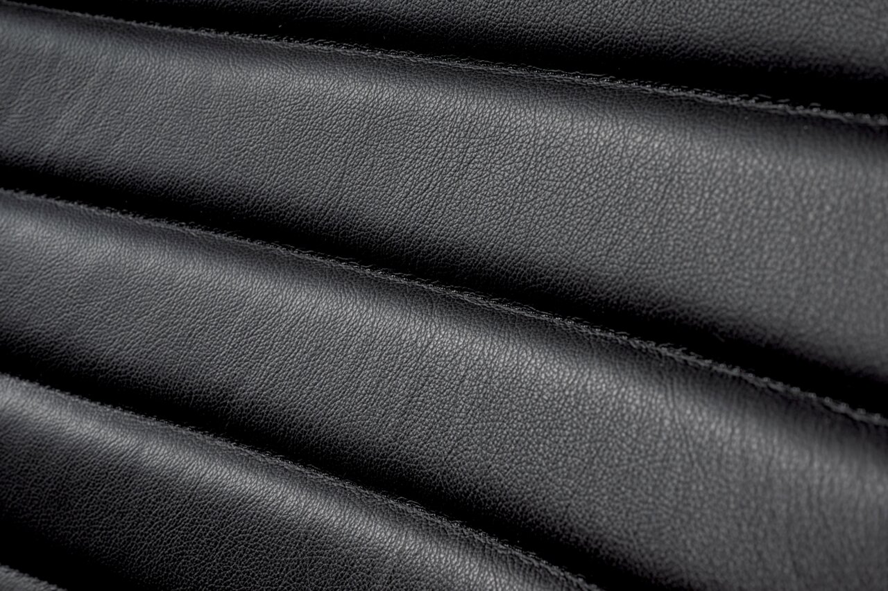 Nahaufnahme der schwarzen Lederpolsterung eines Schwingstuhls in horizontaler Perspektive