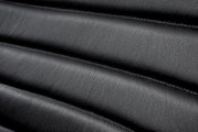 Close-up van de zwarte lederen bekleding van een schommelstoel in horizontaal perspectief