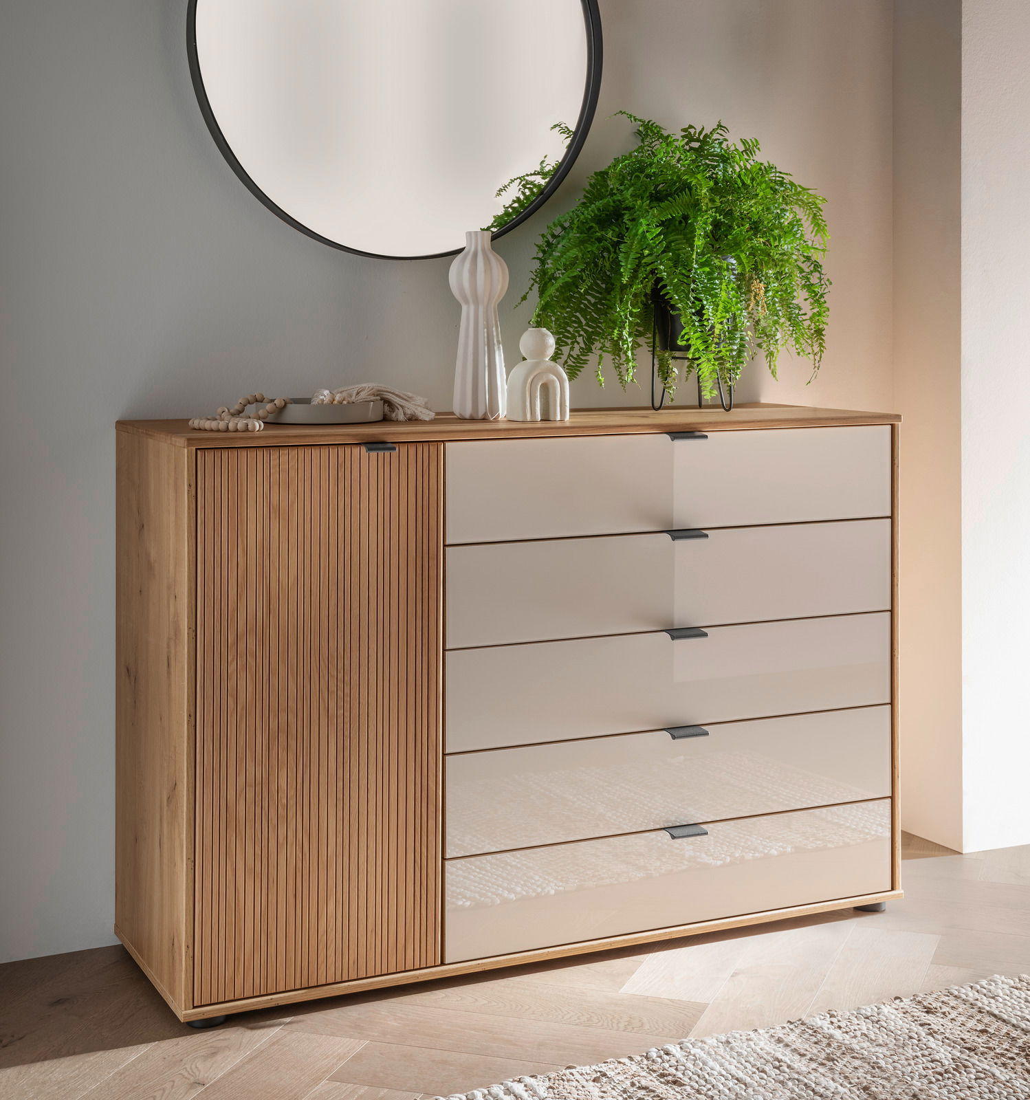 Venda Ladekast met kast NEW YORK Kombikommode aus Holz mit fünf Schubladen und einer Tür, dekoriert mit Pflanzen und Vasen, aus der Frontalperspektive.
