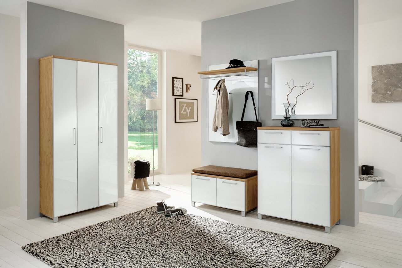 Moderner Flur mit einem großen Spiegel an der Wand, der von vorne sichtbar ist. Der Spiegel hat einen schlichten Rahmen und reflektiert das Licht des Raumes.