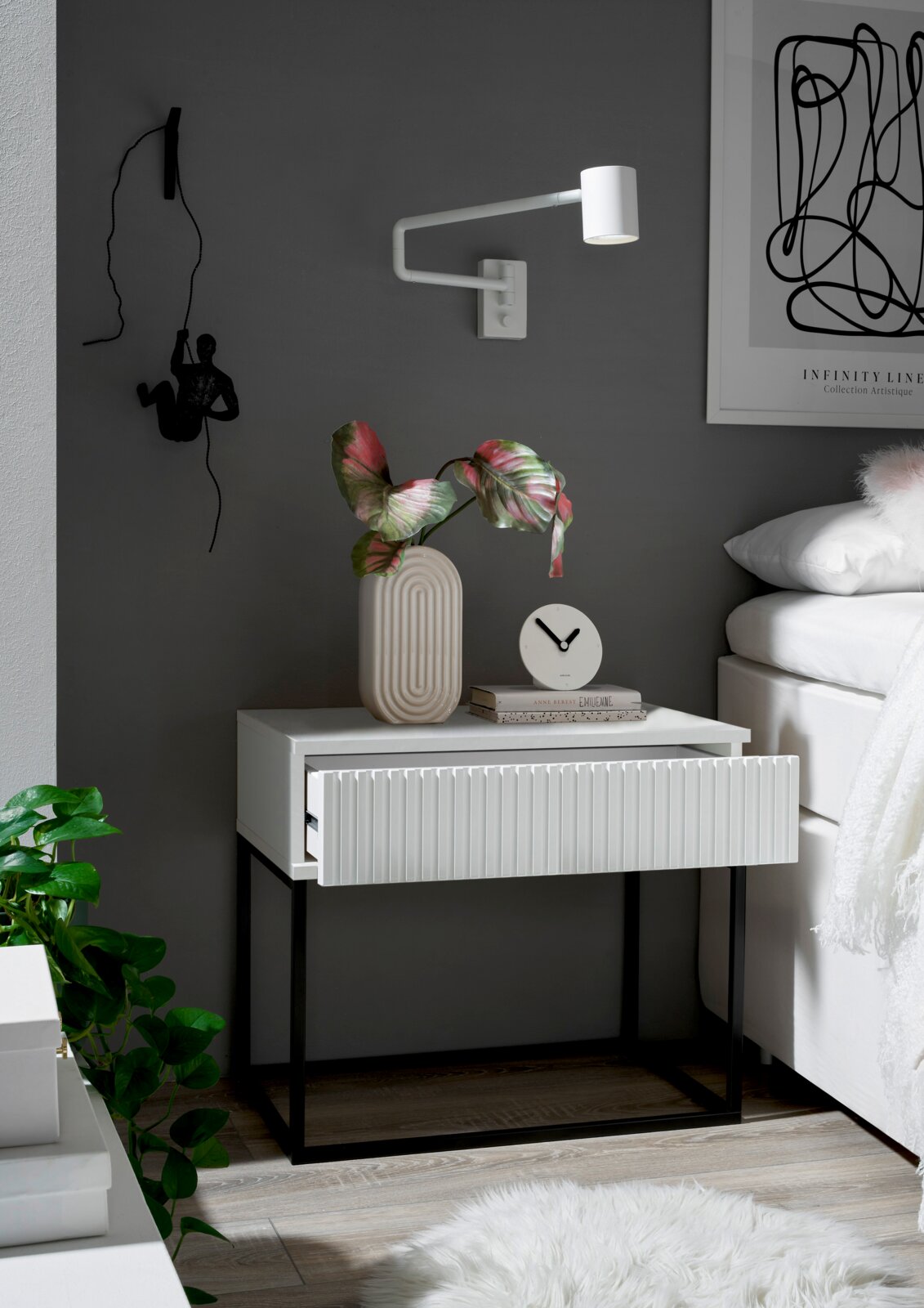Moderne Nachtkommode mit geriffelter Front in einem stilvollen Schlafzimmer, seitliche Perspektive.