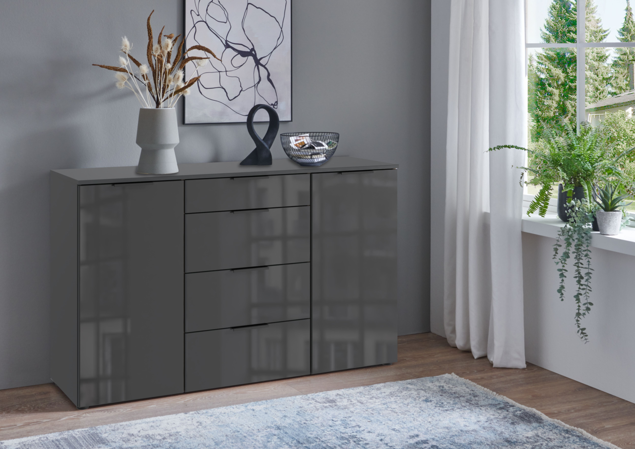 Moderne graue Kombikommode mit Schubladen und Türen, dekoriert mit einer Vase und Kunstobjekten, in einem stilvoll eingerichteten Raum mit Blick aus dem Fenster.