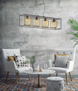 Moderne Pendelleuchte Caydo mit vier Glühbirnen in einem rechteckigen Metallrahmen, hängend über einem stilvoll eingerichteten Wohnzimmer mit zwei Sesseln und einem runden Tisch. Perspektive von vorne.