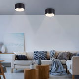 Moderne Deckenleuchte TANIKA in schwarzem Zylinderdesign, von unten betrachtet, in einem stilvoll eingerichteten Wohnzimmer.