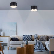 Moderne Deckenleuchte TANIKA in schwarzem Zylinderdesign, von unten betrachtet, in einem stilvoll eingerichteten Wohnzimmer.